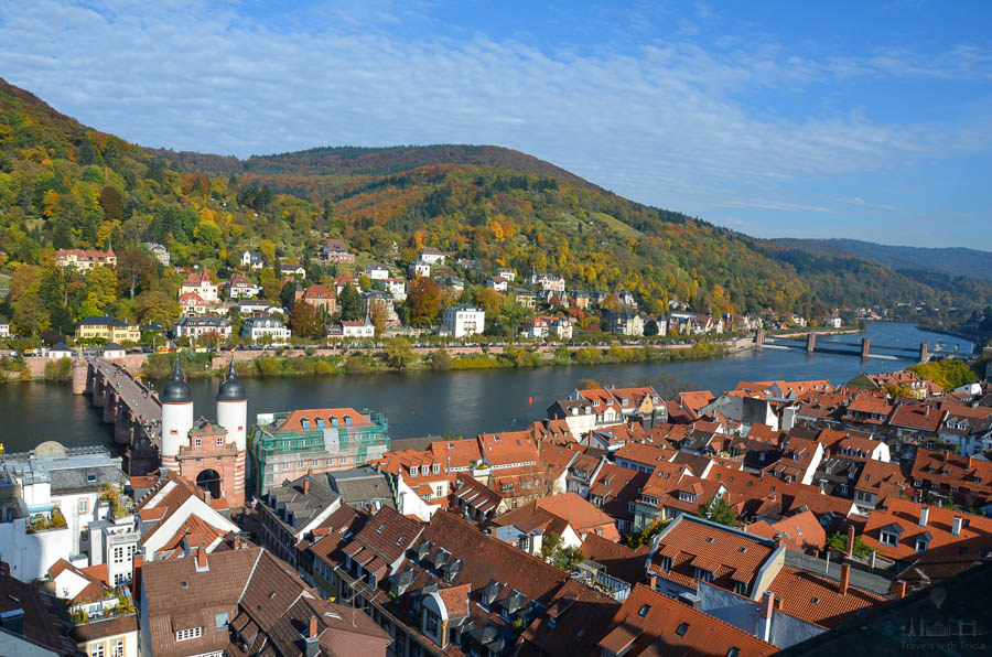 The white towers of the Alte Brucke (Old Bridge) overlook the bridge traversing the Neckar River on an autumn day.