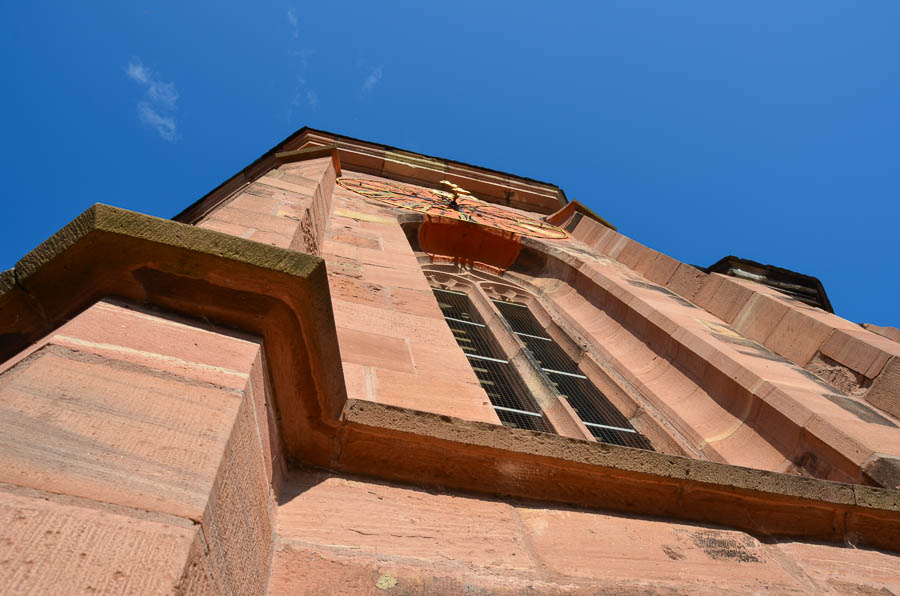 Detail of the pink sandstone of Heidelberg's Heiliggeistkirche (Holy Ghost Church) with a blue sky overhead.