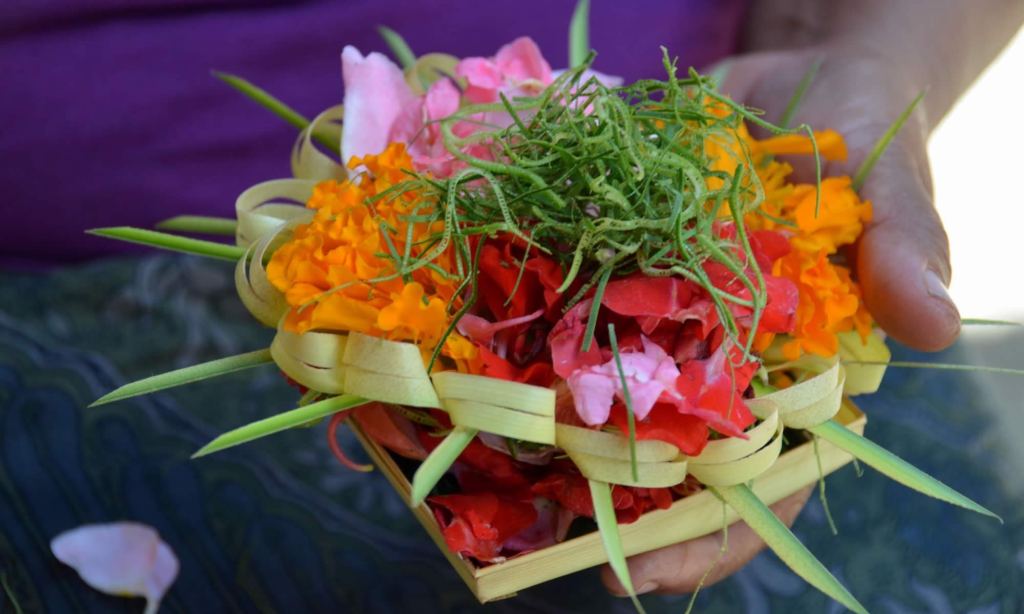 A woman holds Balinese 'canang sari' in her hand. These flowery spiritual offerings are placed in sacred places on the island of Bali.