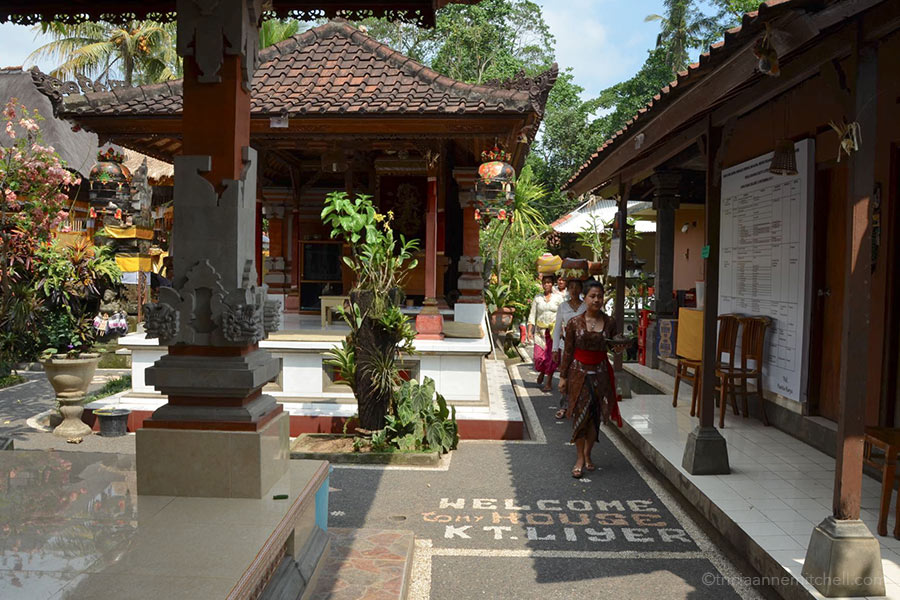 Ketut Liyer home courtyard Women balance baskets of spiritual offerings on their heads as they walk into the inner courtyard of the Ketut Liyer home in Ubud, Bali.