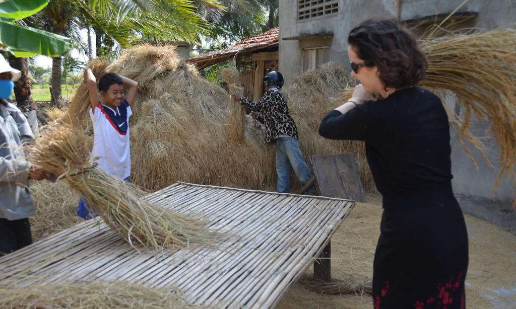 People thresh rice in rural Cambodia.