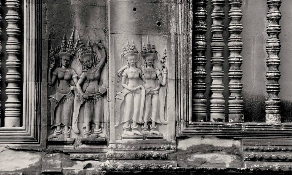 Two pairs of devatas (goddesses) are shown carved into Angkor Wat in Cambodia.