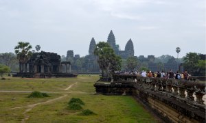 Tourists walk toward Angkor Wat in Cambodia.