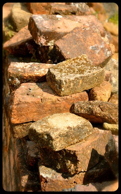 A pile of orange-red bricks at the Wat Phia Wat Ruins in Laos.