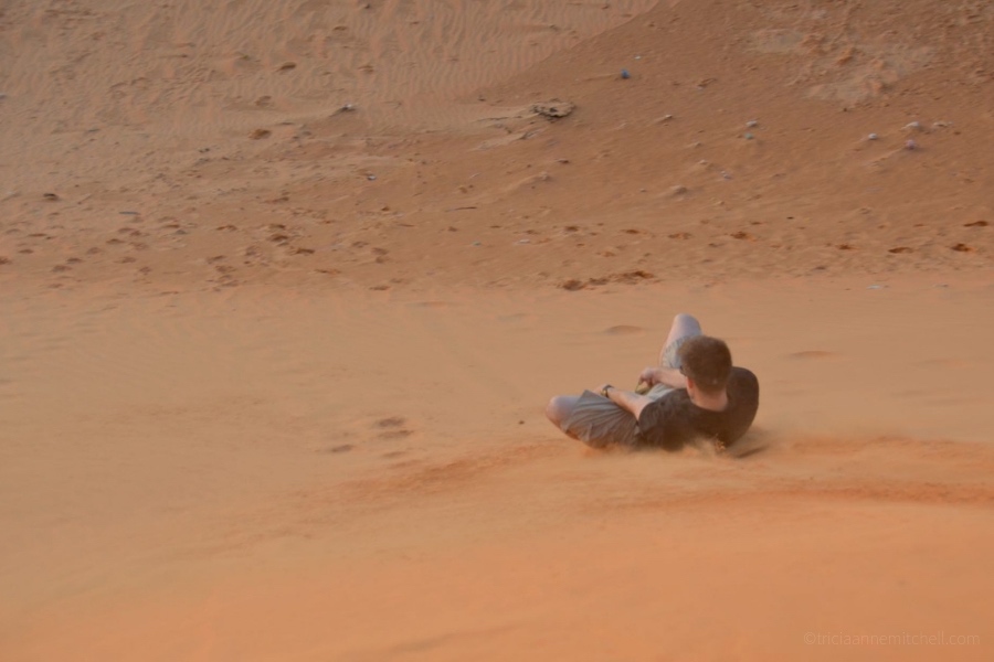 man sandboarding Mui Ne Sand Dunes Vietnam