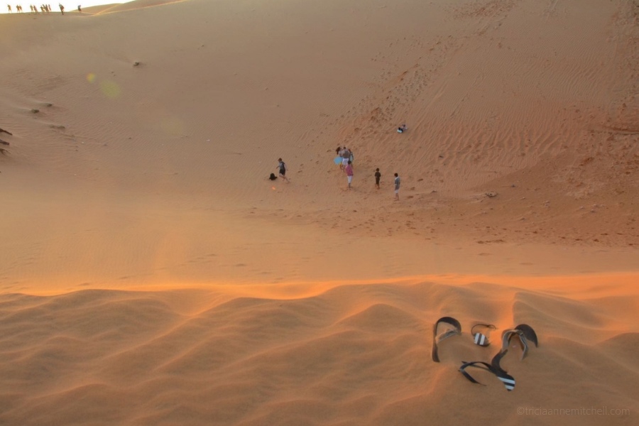 Flip flops, submerged in sand, sit on Mui Ne's Red Sand Dunes.