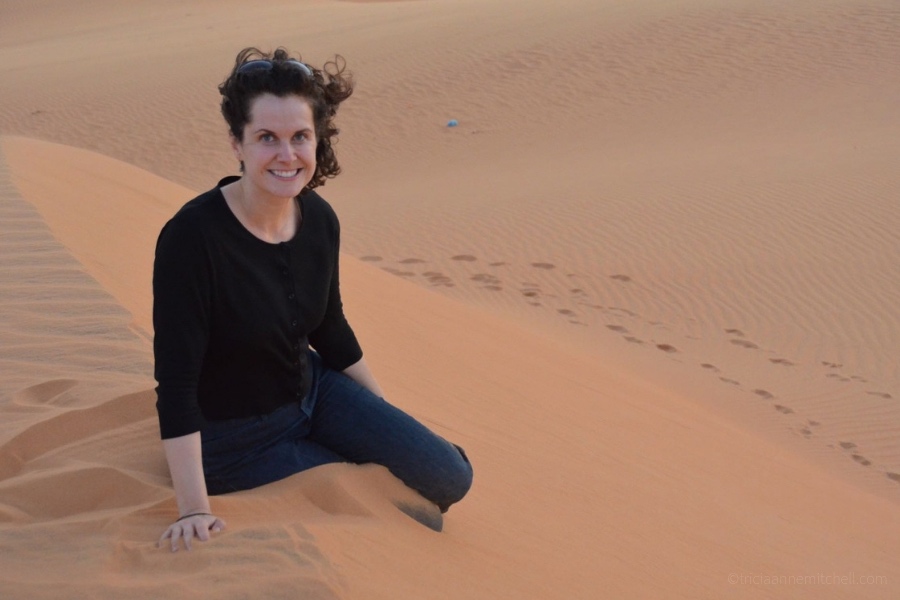 A woman sits on the Mui Ne Red Sand Dune in Vietnam.