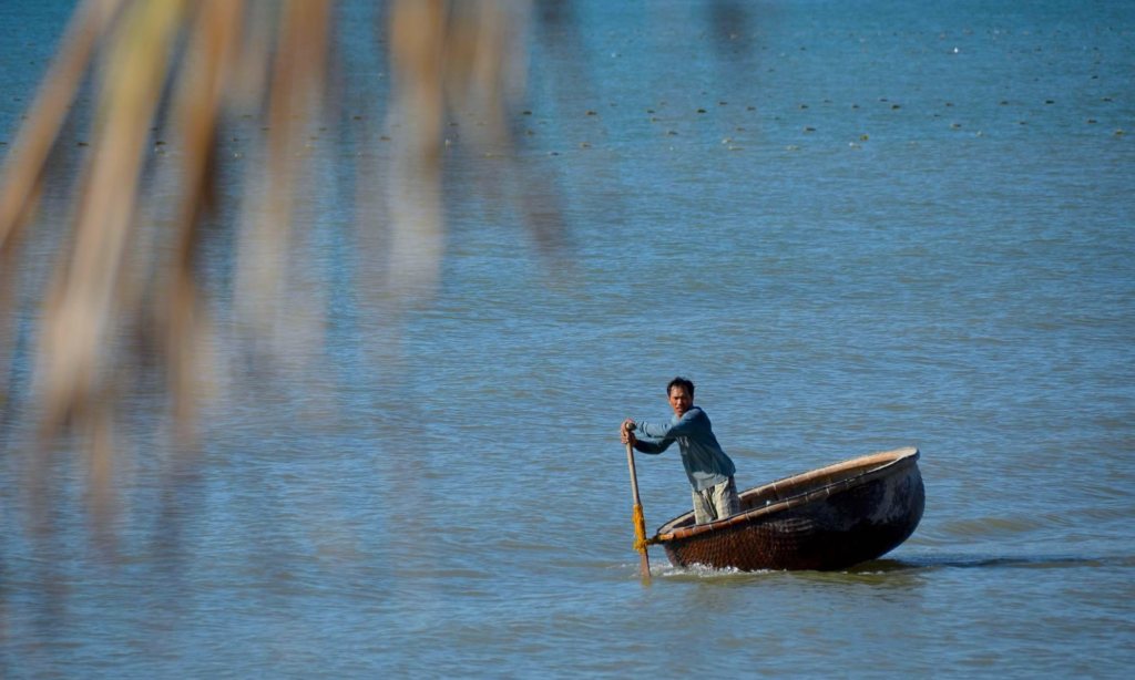 A man paddles a Vietnamese basket boat through the water near Mui Ne.