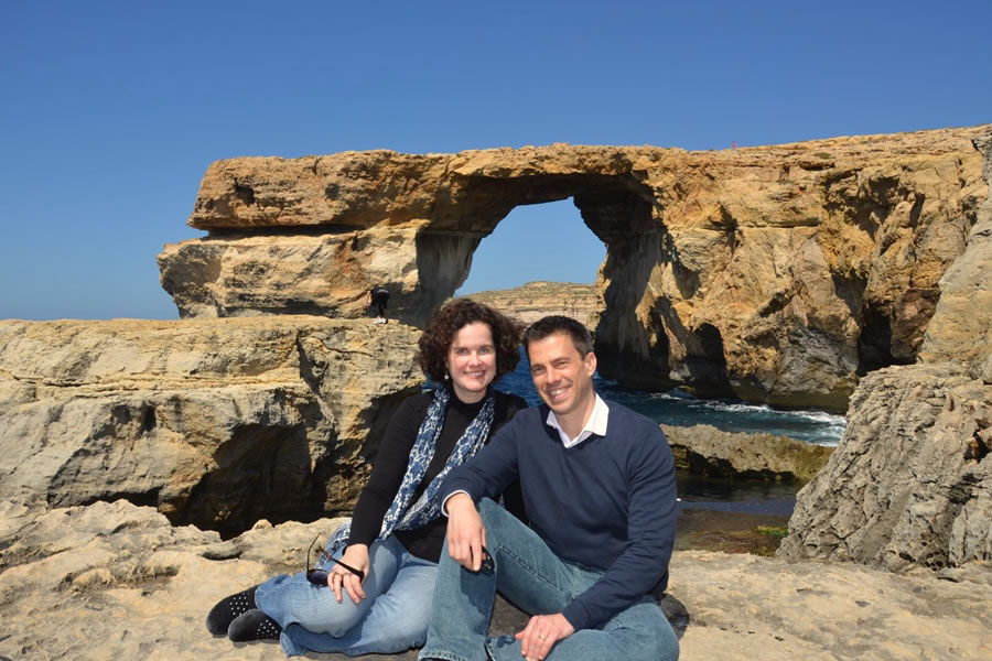 A couple sitting in front of the Azure Window on the Maltese island of Gozo.