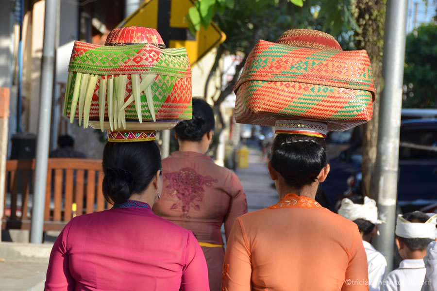 Balinese women carry baskets on their heads containing spiritual offerings.
