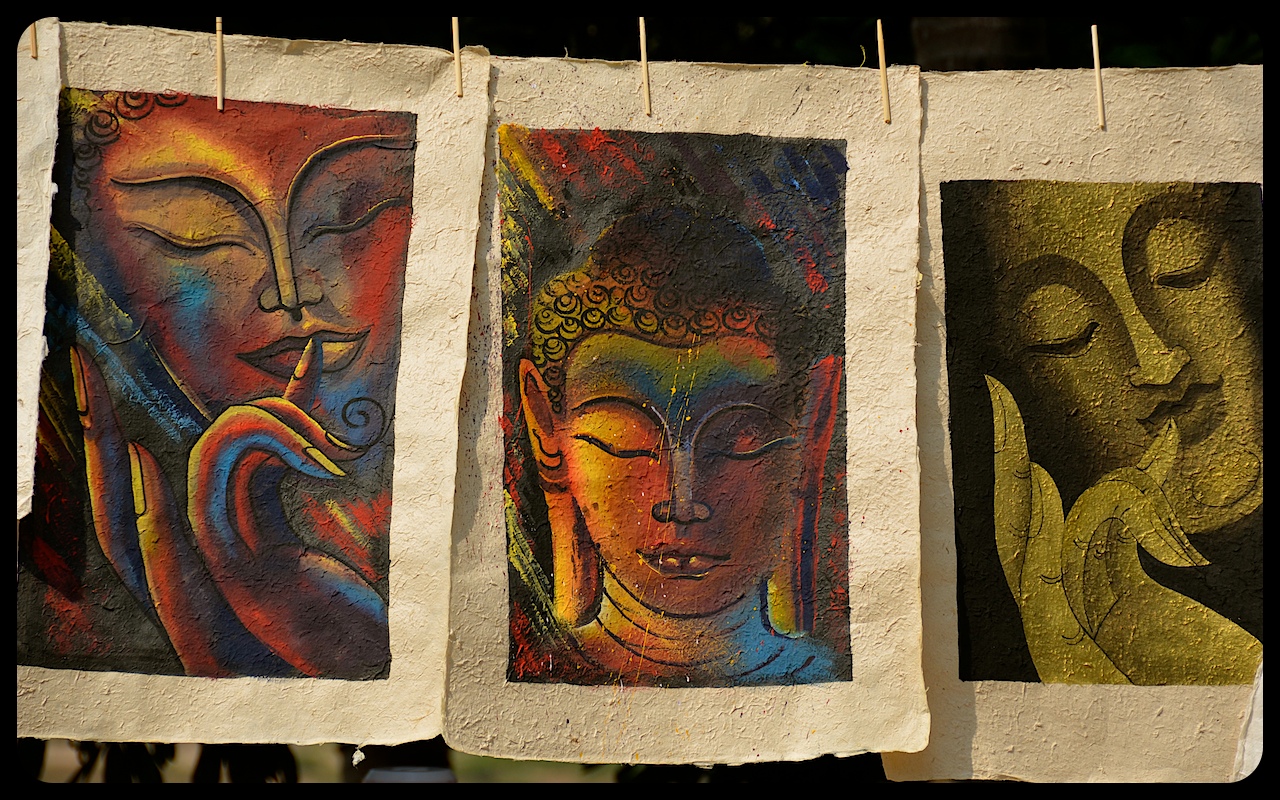 Images of Buddha, painted on hand-made paper, hang for sale at a stand in Luang Prabang, Laos.