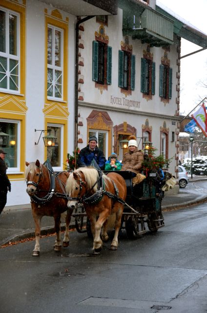 A horse-drawn sleigh carries passengers past frescoed homes in Oberammergau, Germany, on the occasion of St. Nicholas Day.