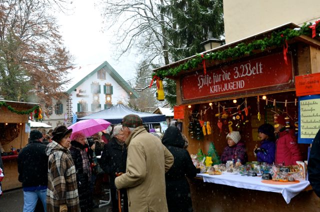 People socialize at an outdoor holiday market in Oberammergau, Germany.