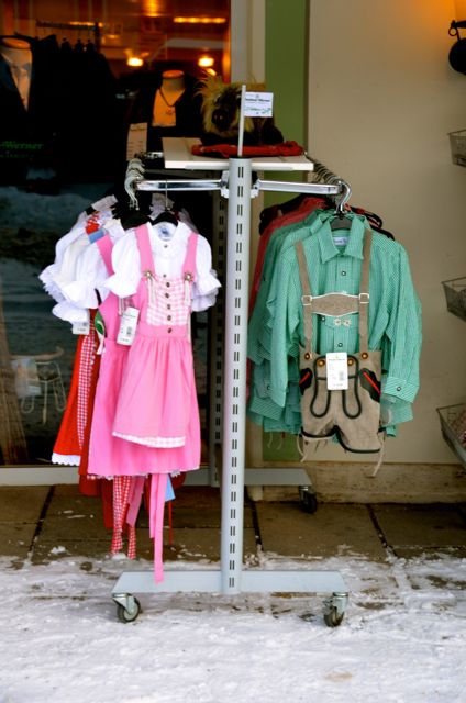 Traditional Bavarian clothes hang outside on clothing racks in Oberammergau, Germany.
