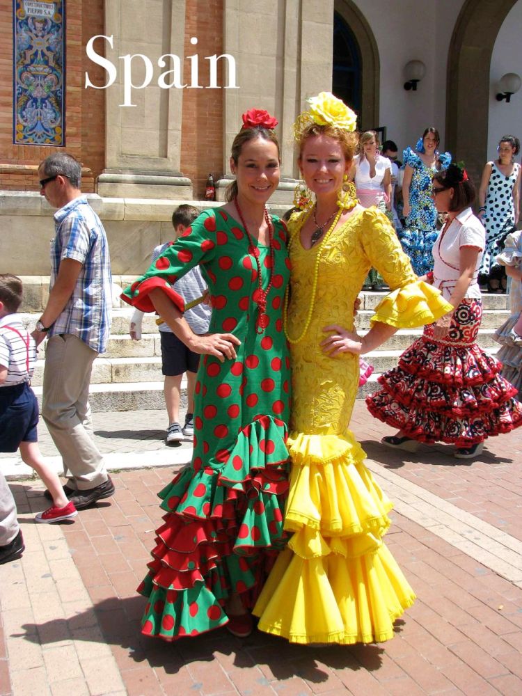 Two women dressed in feria dresses outside of Sevilla, Spain.