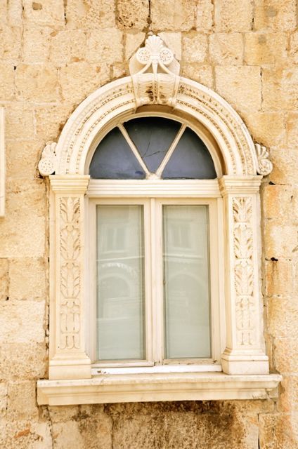 A window frame, which is carved in a decorative fashion, in Trogir, Croatia.