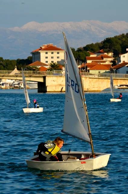 A boy pilots a small sailboat during a lesson in Trogir, Croatia.