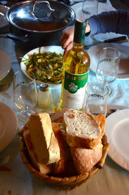 Croatian lunch consisting of wild asparagus and eggs, bread, white wine and chicken and pork
