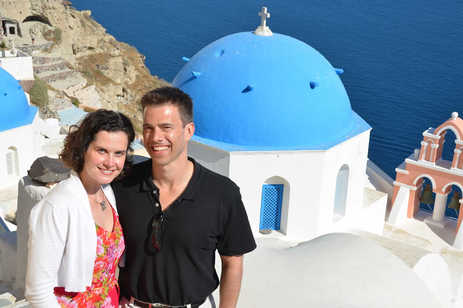 A white building with a blue dome in Oia, Santorini.