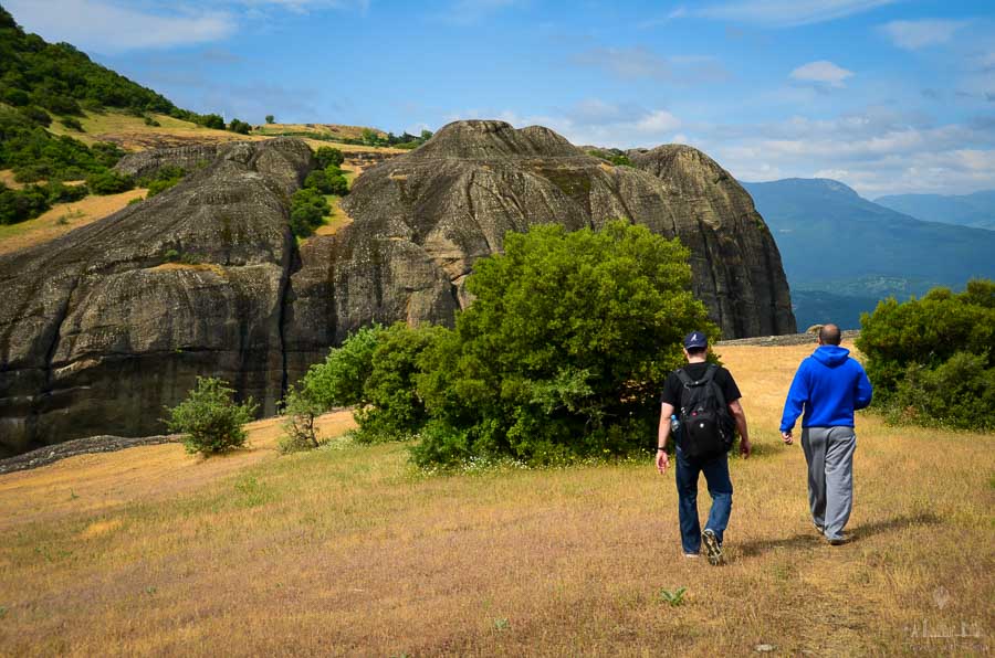 Two tourists walk on top of a rock formation near Meteora, Greece's monasteries, during a hiking tour.
