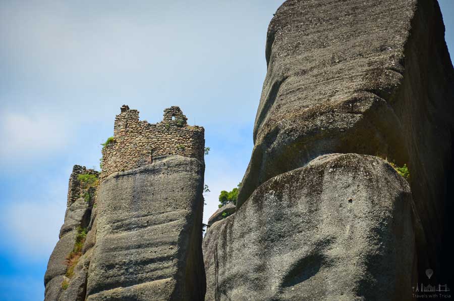 The stone ruins of a monastery sit on top of a rock formation in Meteora, Greece.