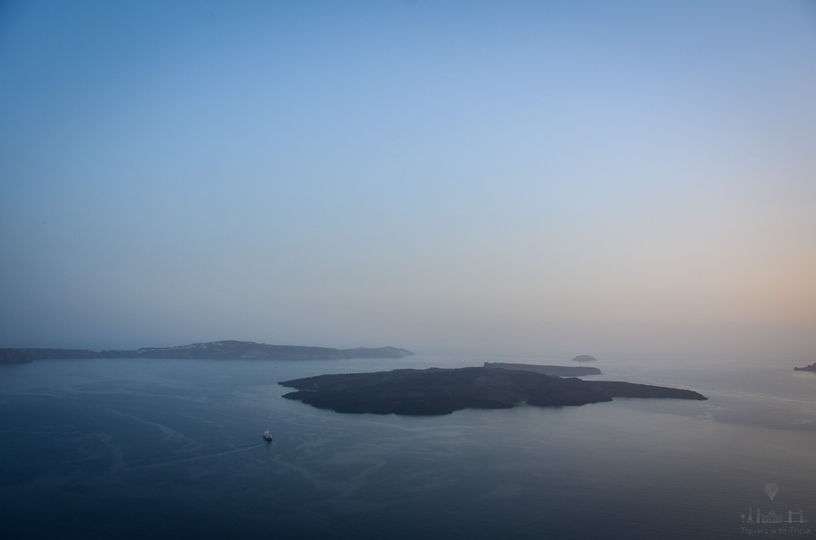The sun sets over Nea Kameni island, Santorini, Greece