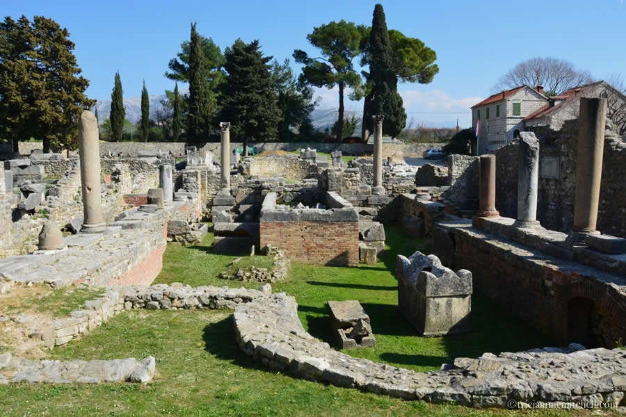 Ruined columns, capitals, walls, and cracked sarcophagi fill the lawn of Ancient Salona's Manastirine section.