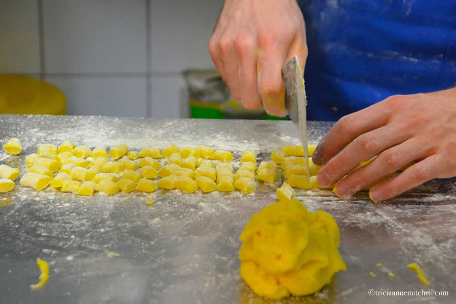 A male chef makes gluten-free gnocchi at a restaurant in Modena, Italy. Only his hands are visible.