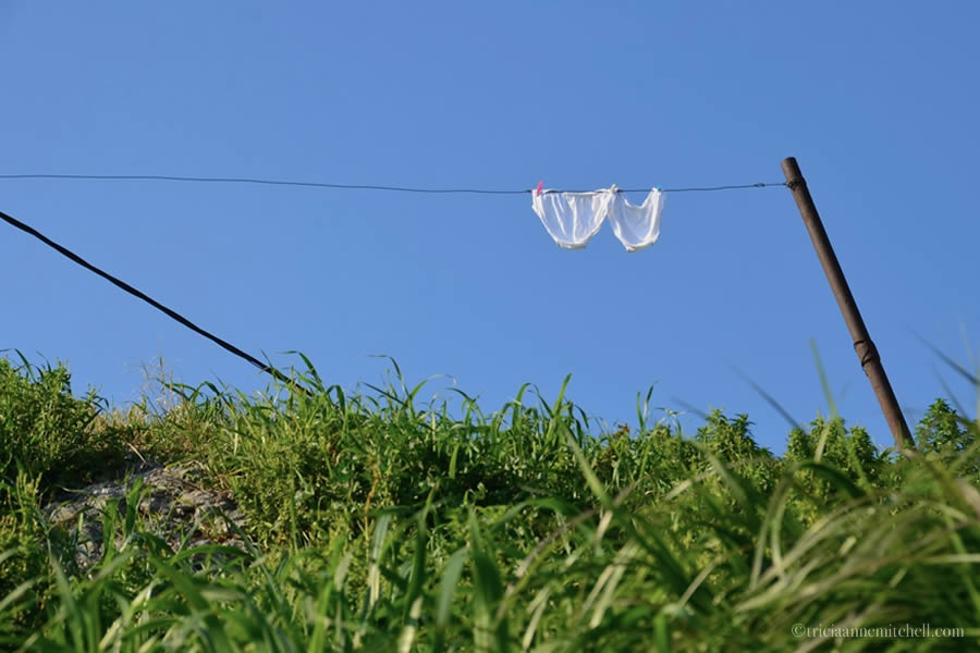 With a blue sky overhead, a pair of white underpants hang on a laundry line near the ancient city of Salona, Croatia.