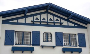 A blue and white house in France's Basque country (Pays Basque) features blue trim, triangles, and shutters.