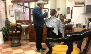 A man cuts a customer's hair at a barber shop in Split Croatia