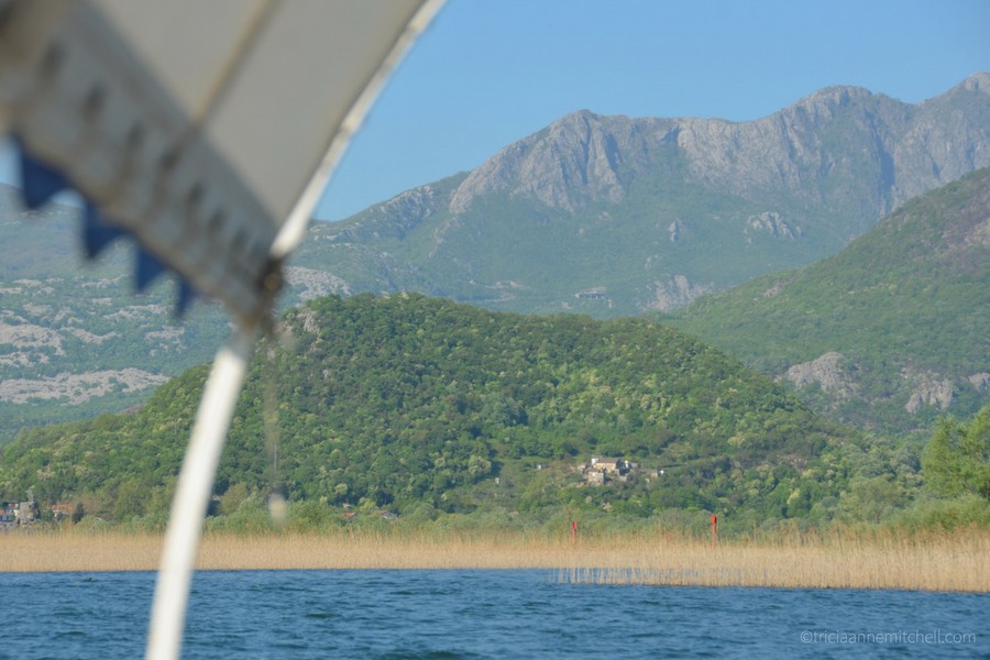 Rugged mountains and a forested hill fill the landscape by Lake Skadar.