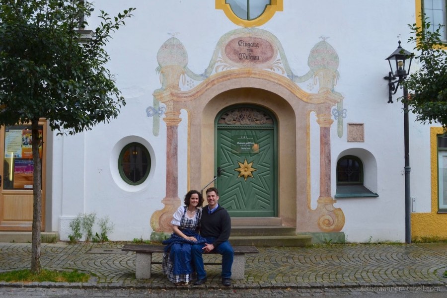 A couple sits in front of the entrance of Oberammergau's town museum.
