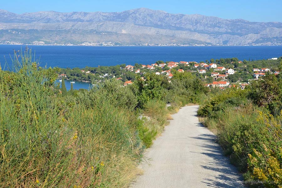 A small road leads towards a village along the coast of the Croatian island of Brač. 