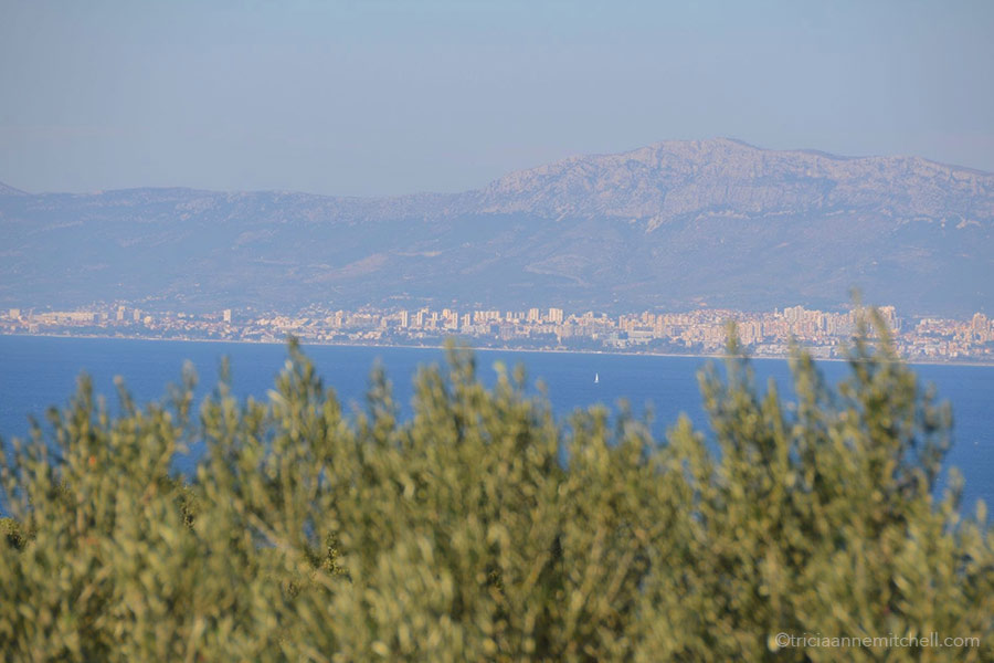 Looking at the city of Split from the neighboring island of Brač. A city skyline, mountains, and sea are visible.