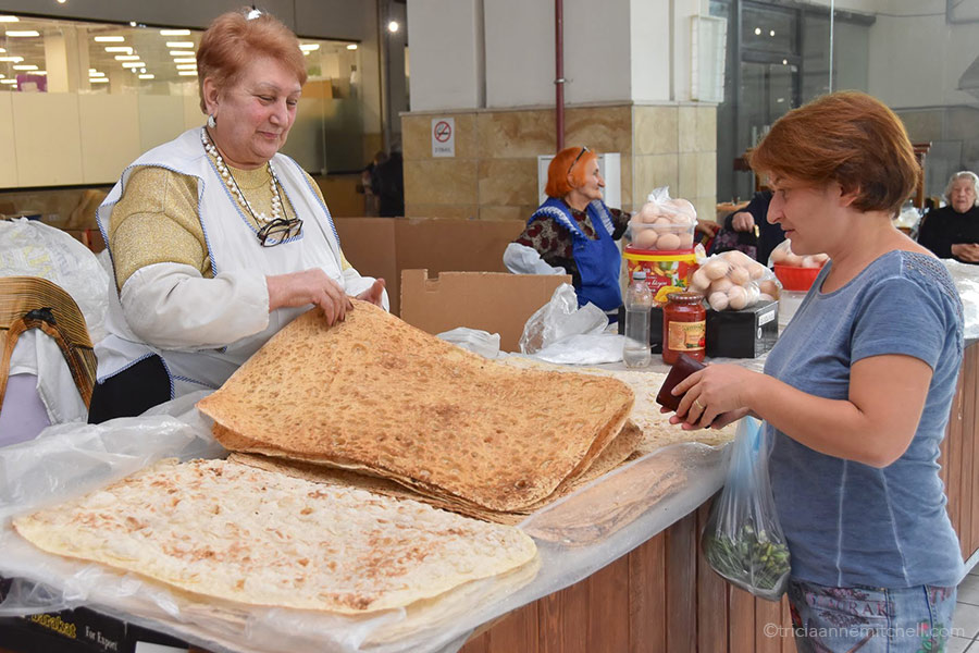 A vendors counts sheets of lavash at a Yerevan fresh-food market.