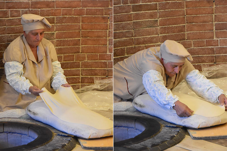 A woman places elastic lavash dough on a baking cushion.