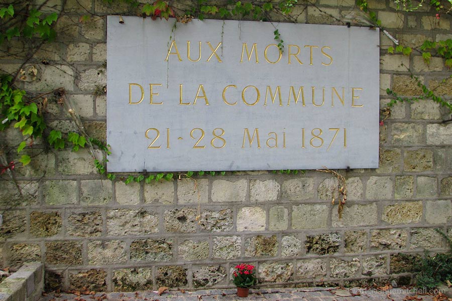 A sign on a stone wall in Père Lachaise Cemetery reads: "Aux morts de la Commune 21-28 Mai 1871"