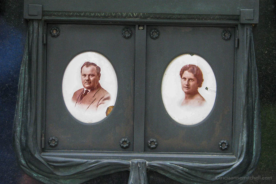 Two sepia portraits of a man (left) and woman (right) decorate the grave of the Pere Lachaise Cemetery.