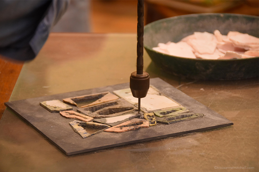 A master artisan attaches a fragment of semi-precious stone to a slate board, as he prepares the stone for cutting.