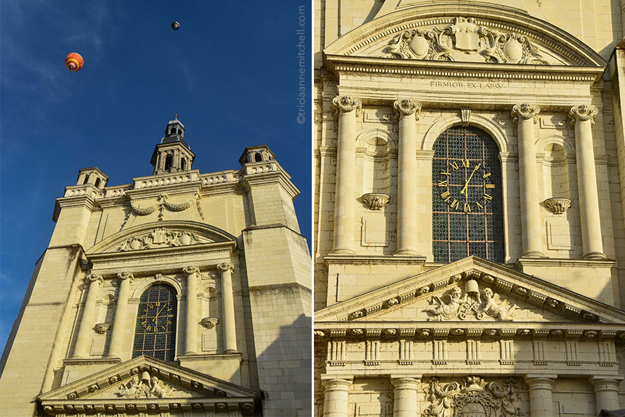 Hot air balloons fly over the rooftop and tower of the Saint Peter Church in Saumur, France.