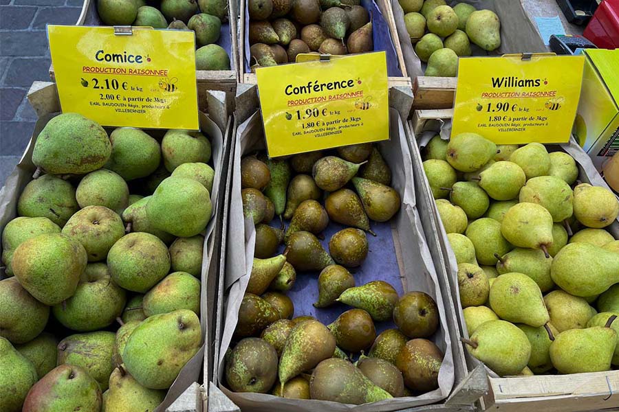 Crates filled with 3 varieties of pears for sale, including Comice, Conférence, and Williams at Saumur's Saturday market.