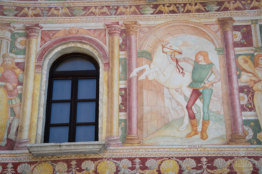 Detail of the ornate façade of the Palazzo Dipinto. There is a fresco depicting a man holding the reins of a white horse.