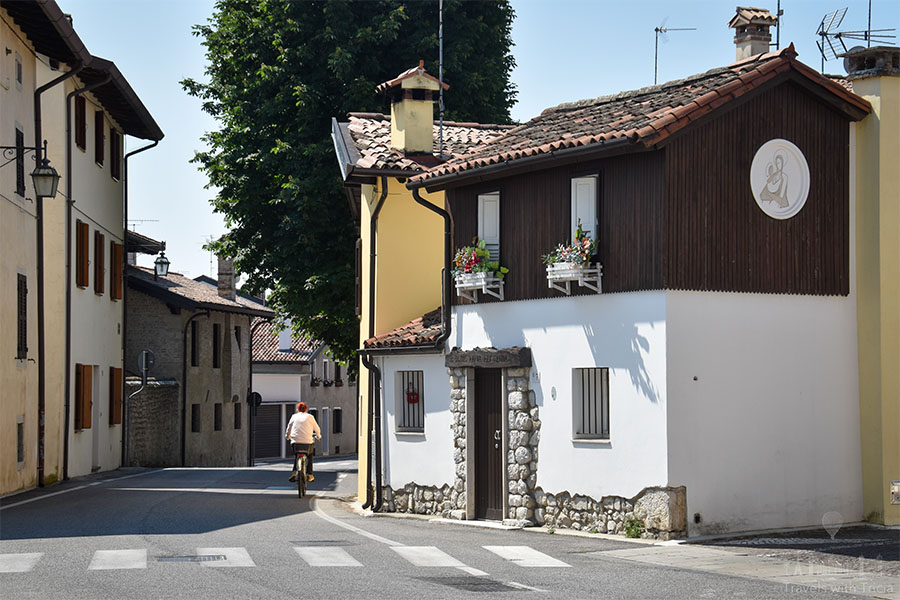 A woman rides a bike through Spilimbergo's streets.