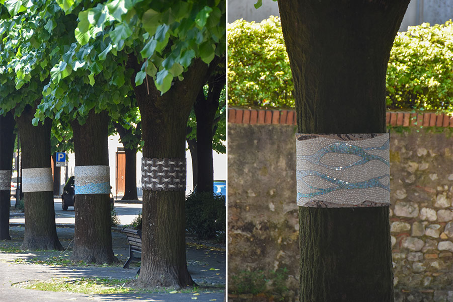 Trees line the street of Spilimbergo. Mosaic bands wrap around the trunks like belts.