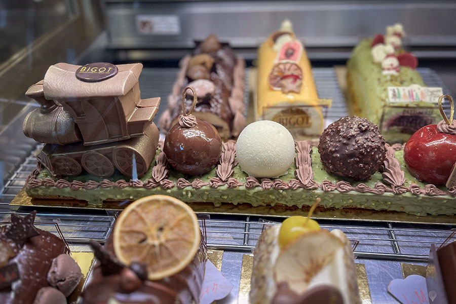A display window at the Bigot Pastry Shop is traversed by an edible train made with chocolate, frosting, and more.