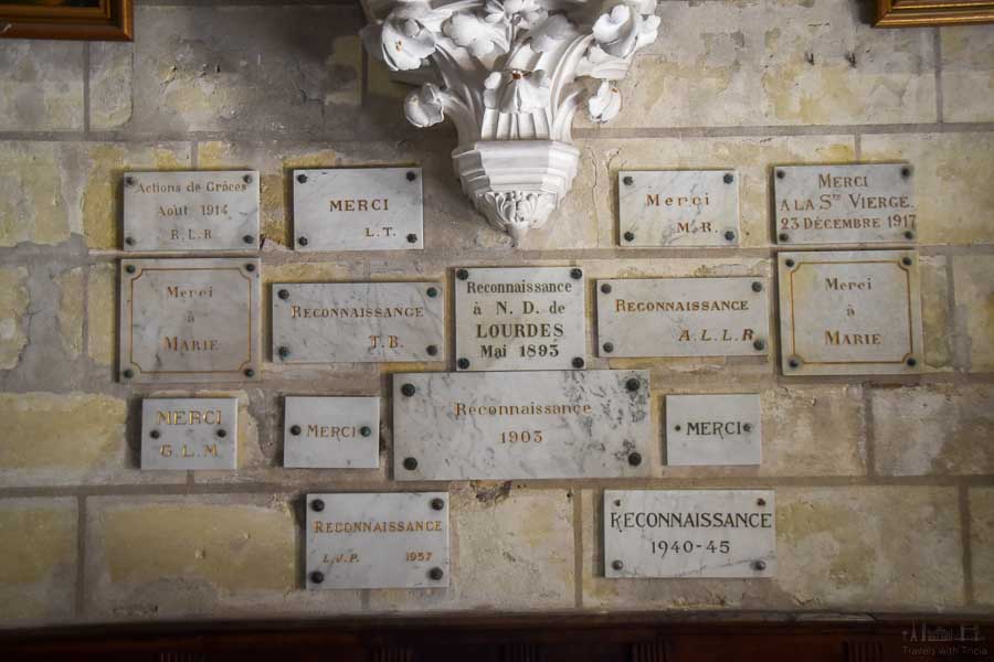 Marble plaques are affixed to the interior stone wall of the Saint Martin et Saint-Médard Church in Cinq Mars la Pile, France. They express thanks and are written in French.