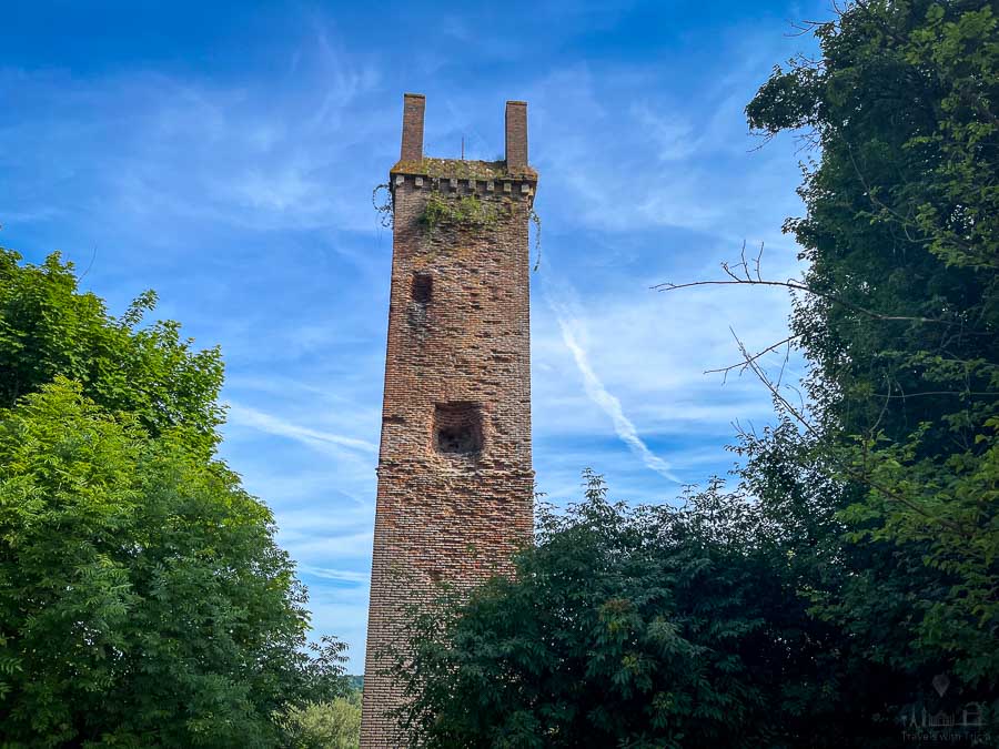 The Pile de Cinq Mars (a brick Gallo-Roman tower) rises above the treetops on a hillside in the town of Cinq Mars la Pile, France.